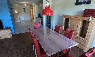 Esstisch und Küche im Hintergrund im Apartment im Hafendorf Müritz