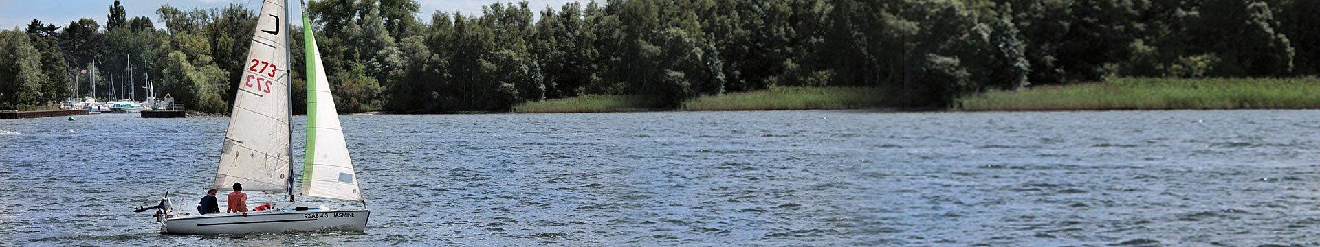 Eine Jolle segelt über einen See.