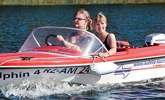 Zwei Frauen fahren ein flottes kleines Motorboot.