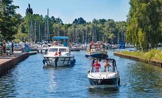 Zahlreiche Motorboote verlassen das Hafendorf in Richtung Müritz.